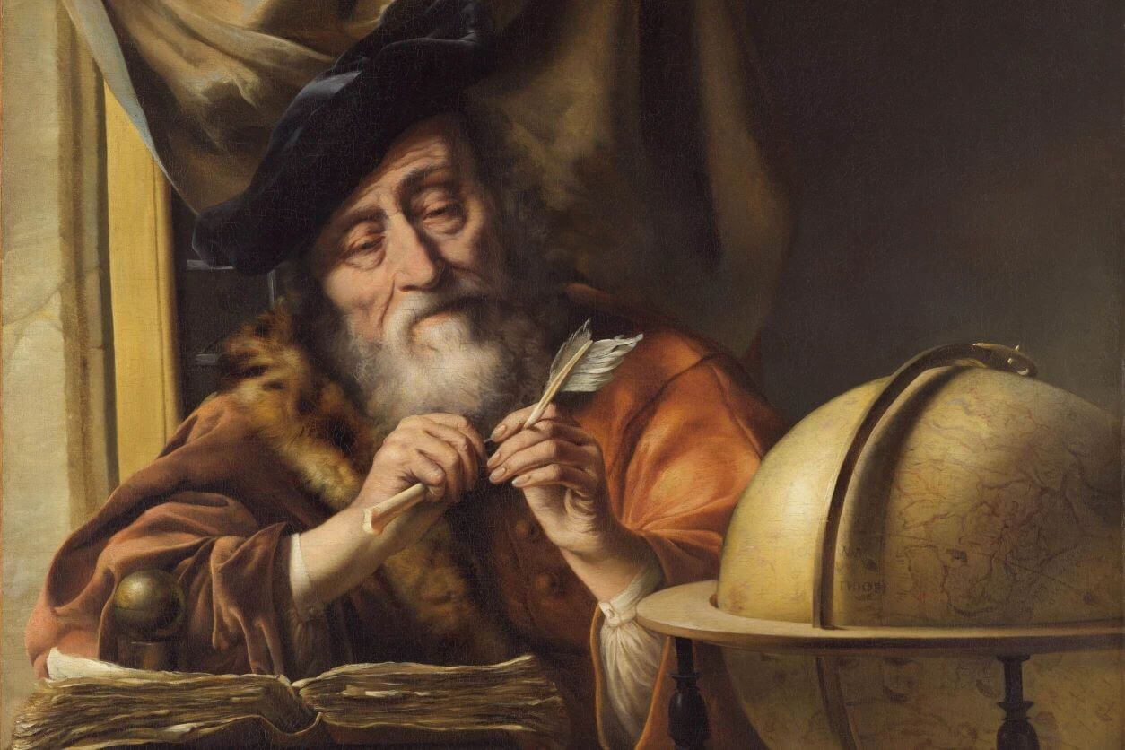 A scholar sharpening his quill, sitting at his desk with book in front of him.