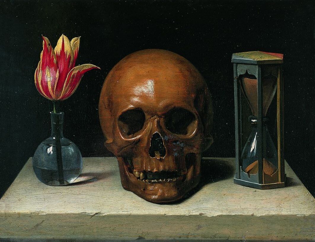 A vanitas still life of a skull flanked by a blooming flower and an hourglass.