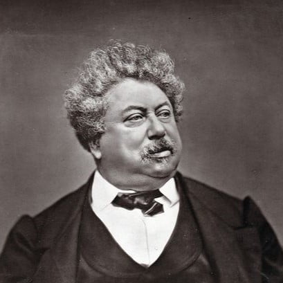A black and white photo of an older Alexandre Dumas in a suit.