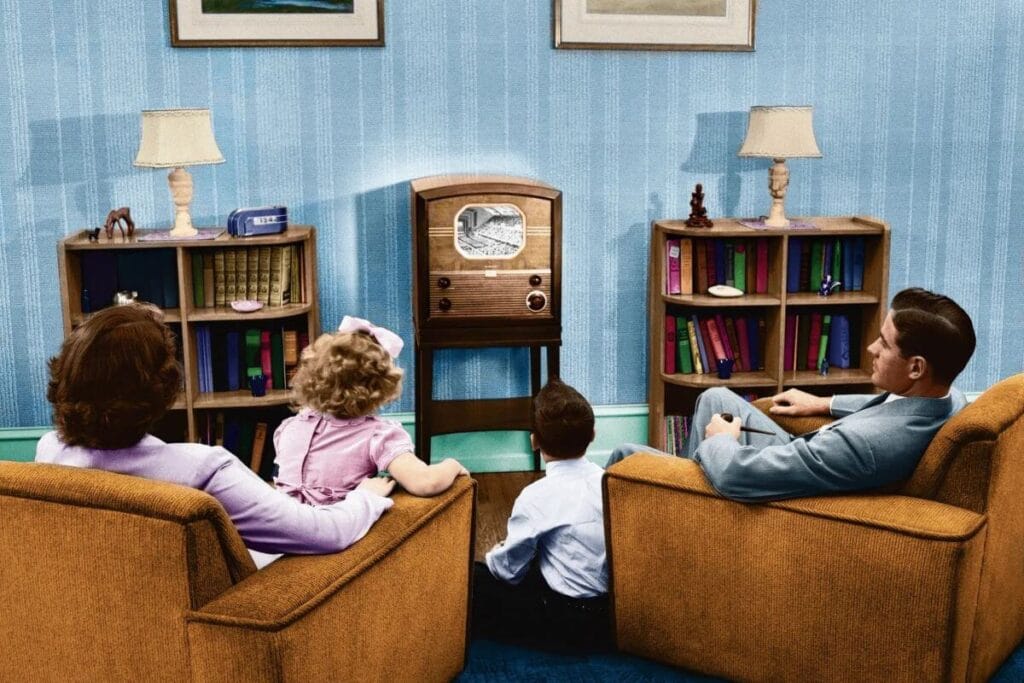 A photo of an American family watching television together in the living room.